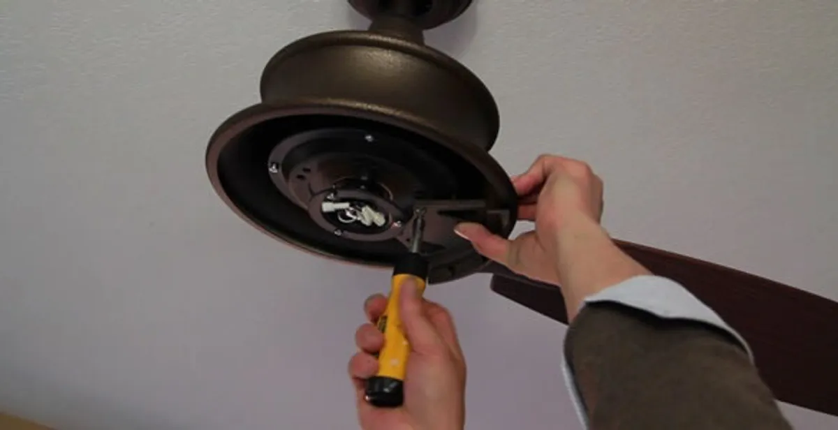 Electrician installing ceiling fan mounting bracket and fixture in Tucson, AZ