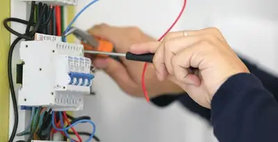 Electrician installing and adjusting circuit breakers in an electrical panel in Tucson, AZ