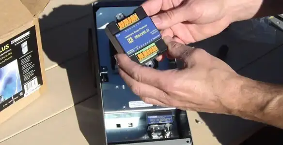 Electrician installing whole home surge protection unit inside main electrical panel in Tucson, AZ