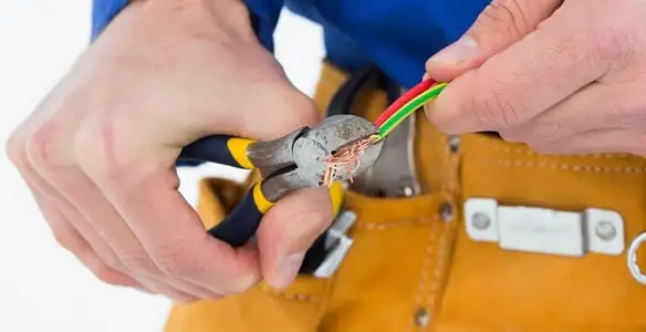 licensed electrician securing electrical wiring with professional tools during service work in Tucson, AZ