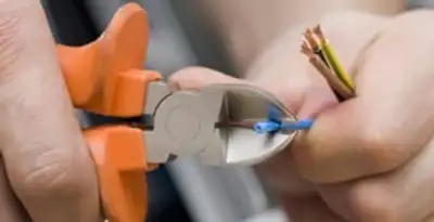 licensed electrician performing precise wire cutting and preparation during electrical service in Tucson, AZ