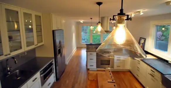 Residential electrician installing modern indoor light fixture in a home in Tucson, AZ